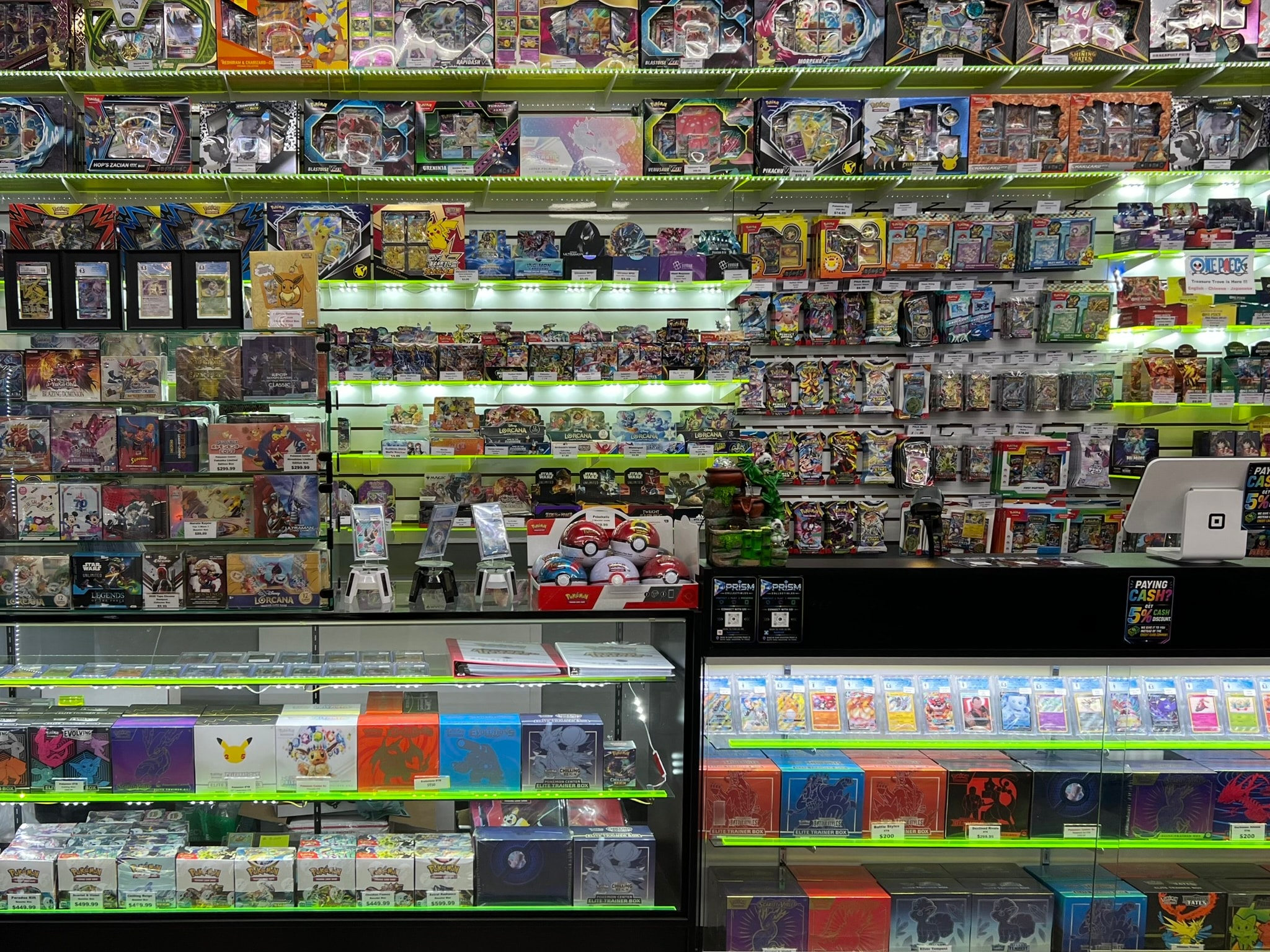 Prism Collectibles product wall — floor-to-ceiling sealed TCG product and glass display cases