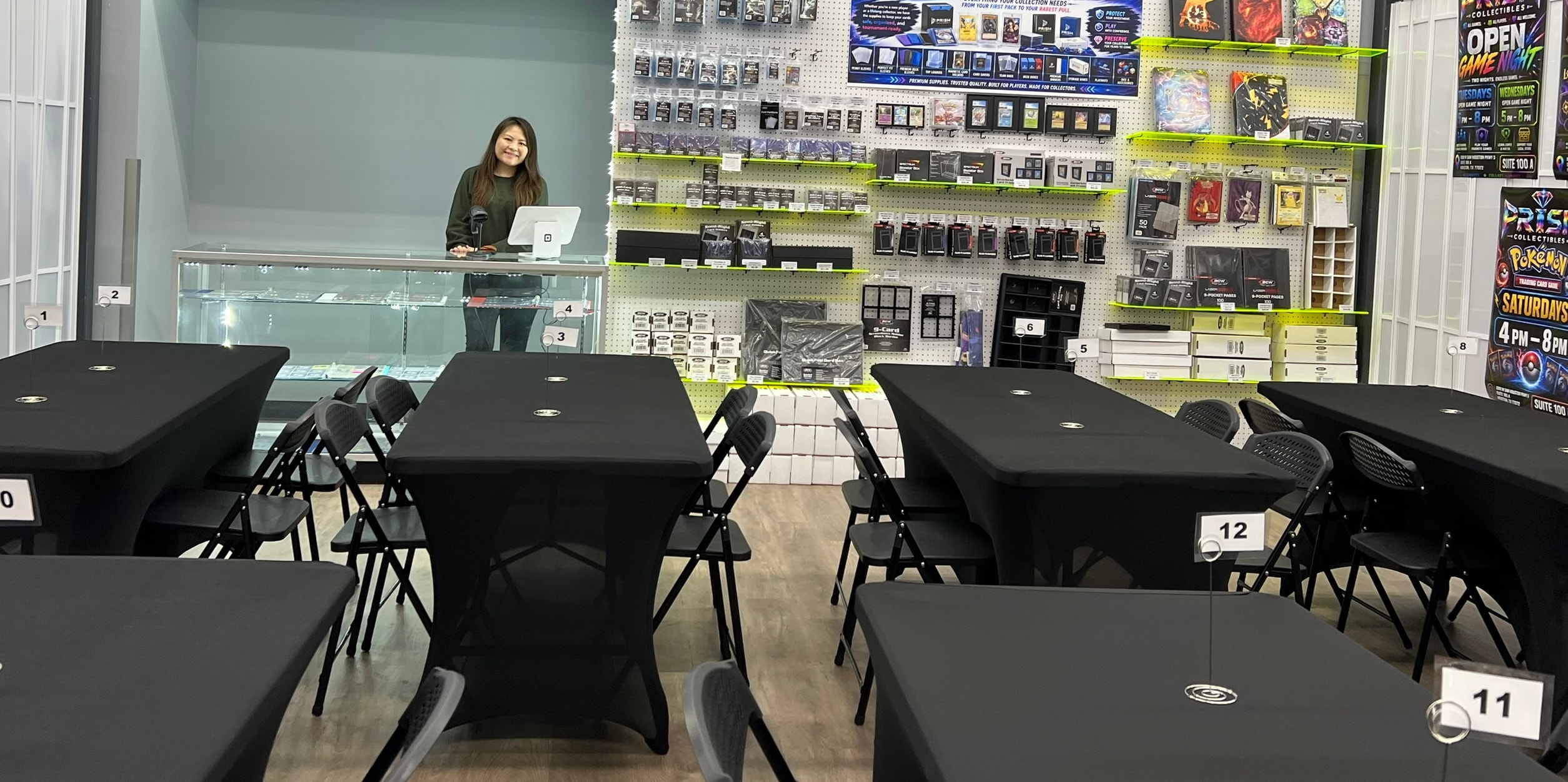 Prism Collectibles product wall — floor-to-ceiling sealed TCG product and glass display cases with singles